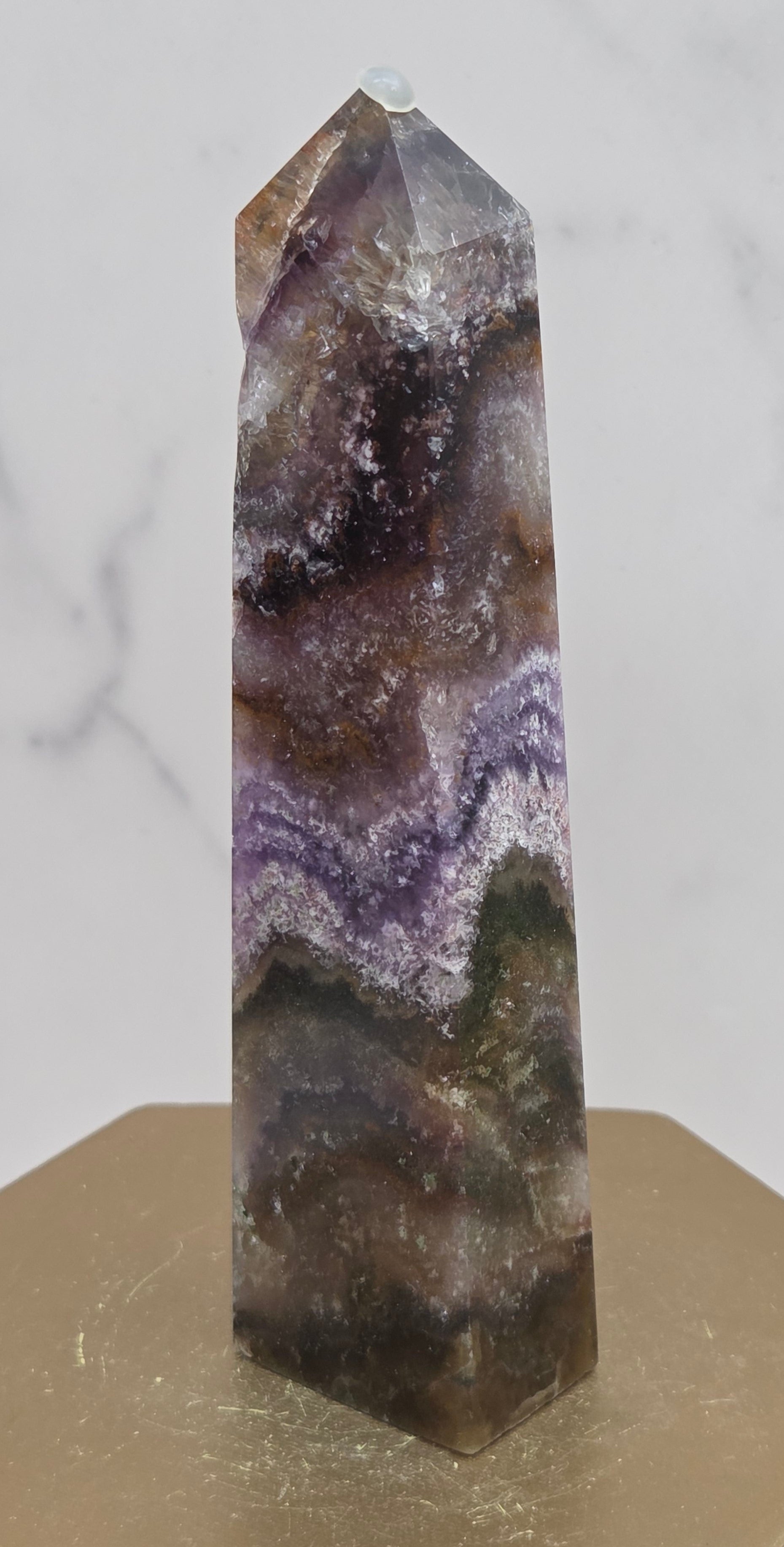 Crystal with purple and brown colors on a marble surface
