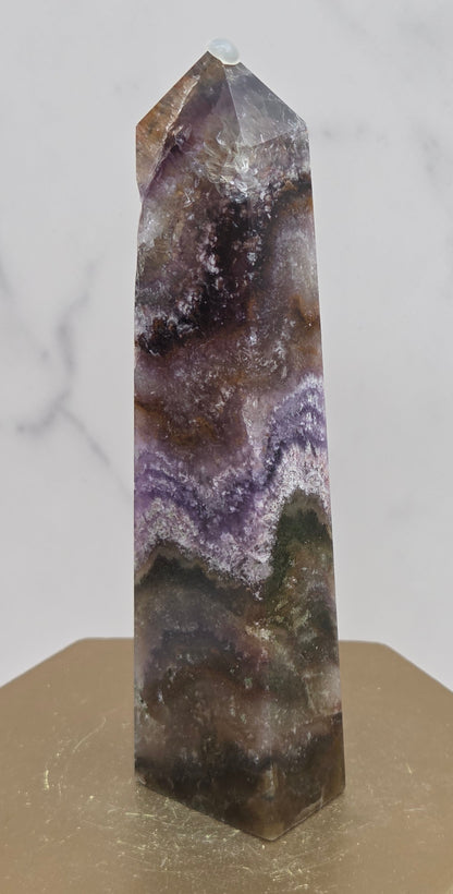Crystal with purple and brown colors on a marble surface
