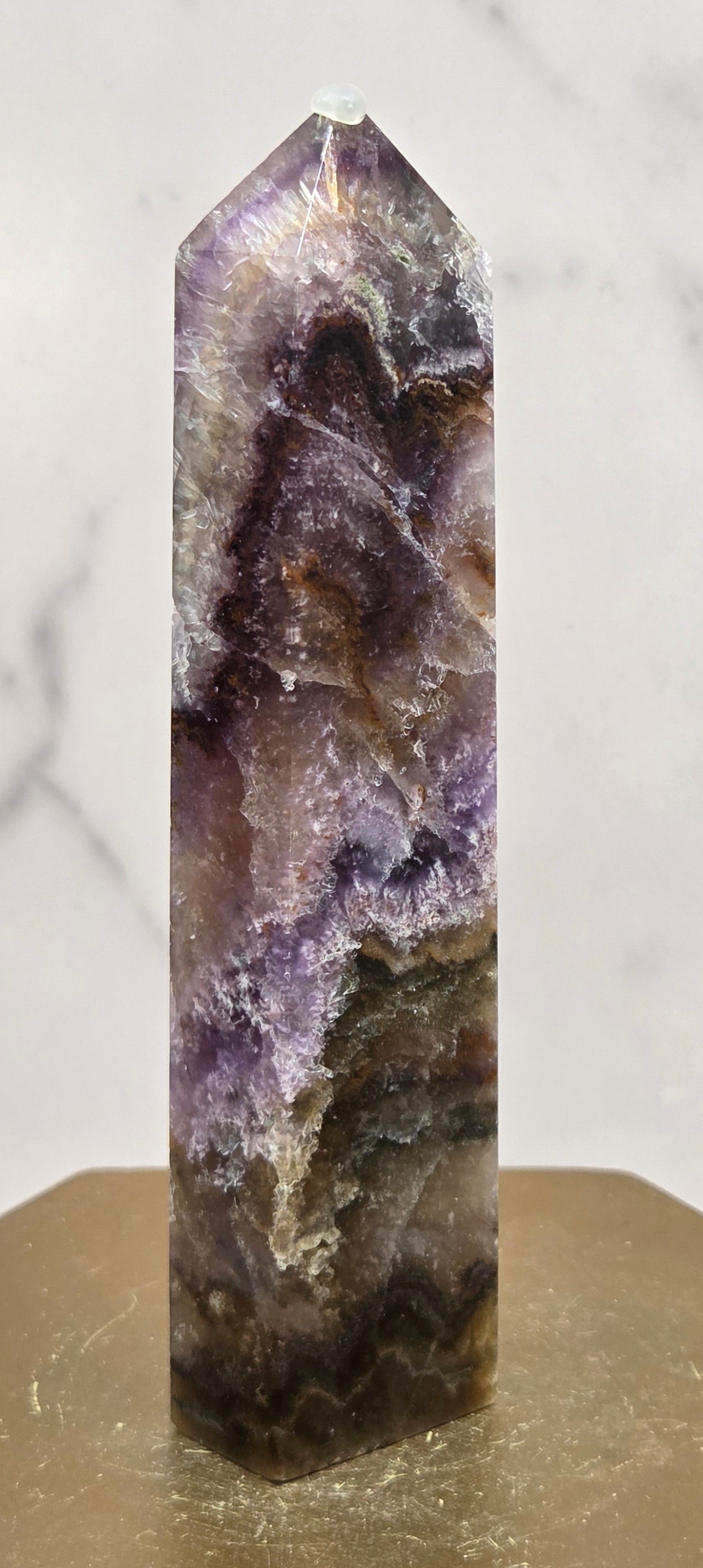 Crystal with purple and brown colors on a marble surface