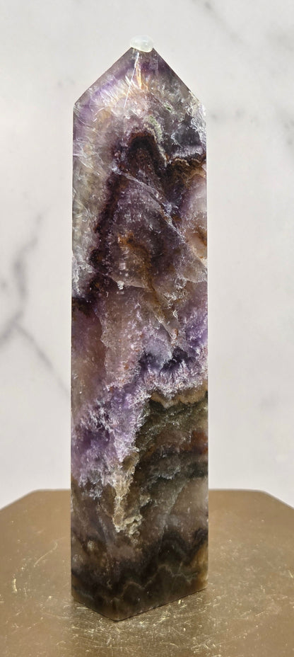 Crystal with purple and brown colors on a marble surface