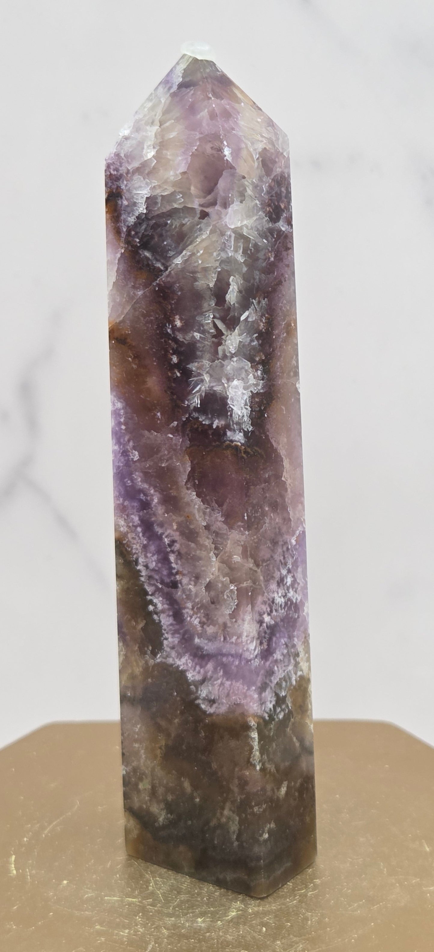 Crystal with purple and brown colors on a marble surface