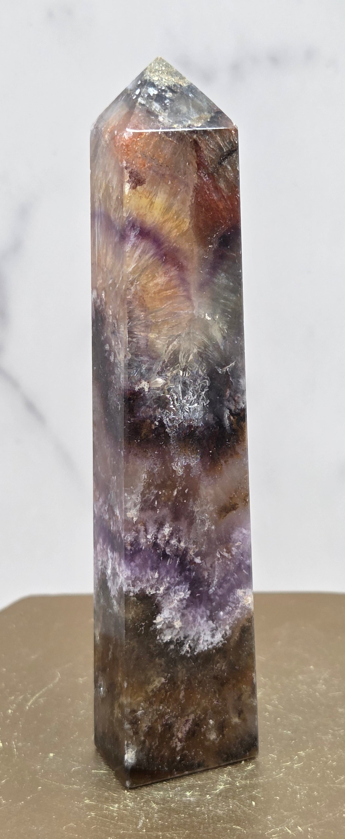 Crystal with purple and brown colors on a marble surface