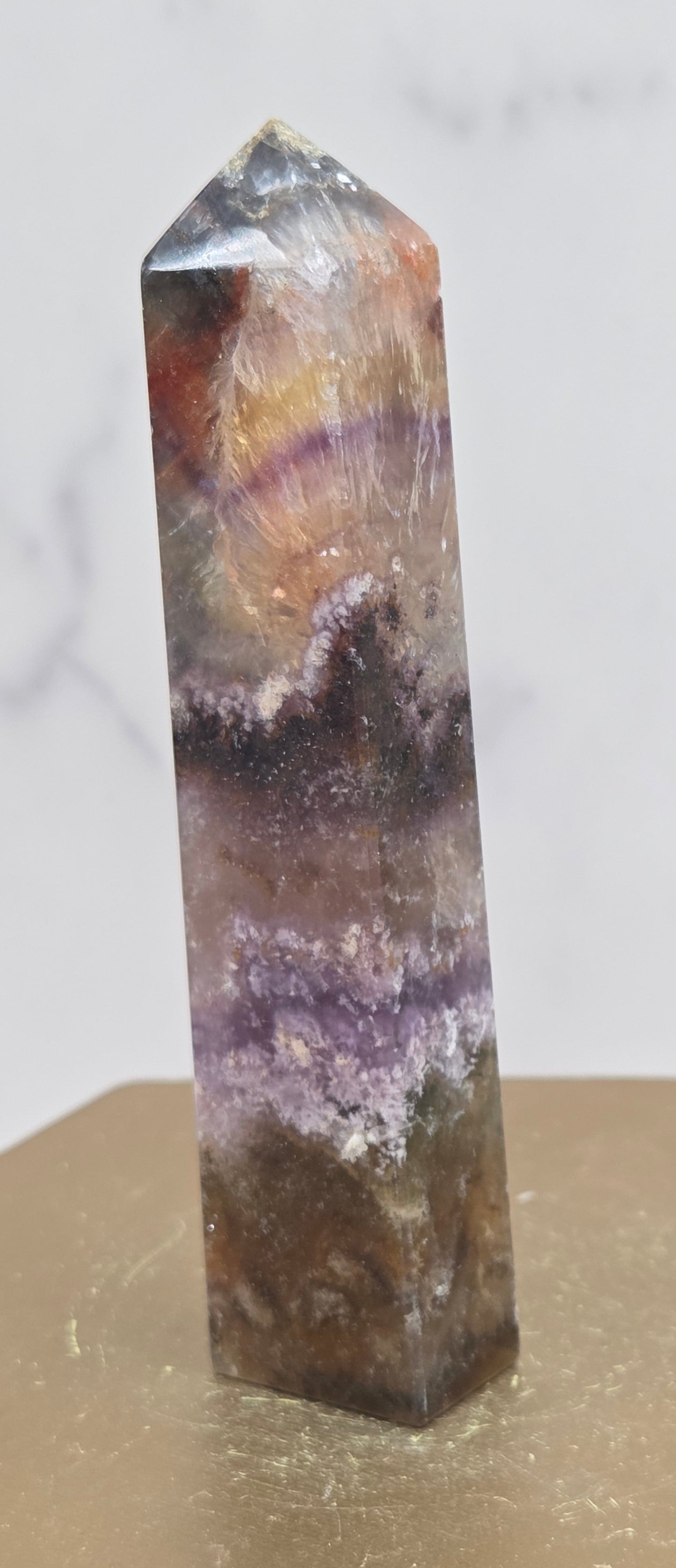 Crystal with purple and brown colors on a marble surface