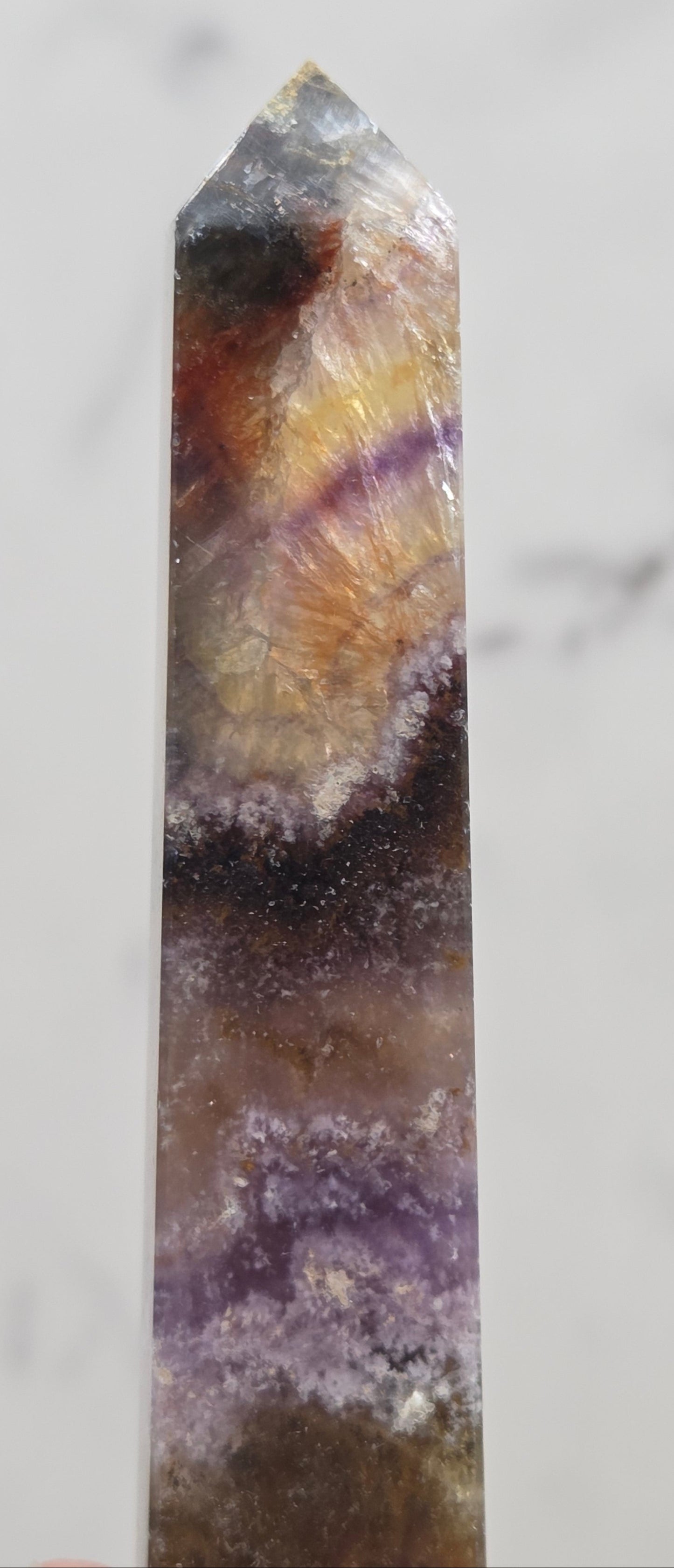 Crystal with purple and brown colors on a marble surface