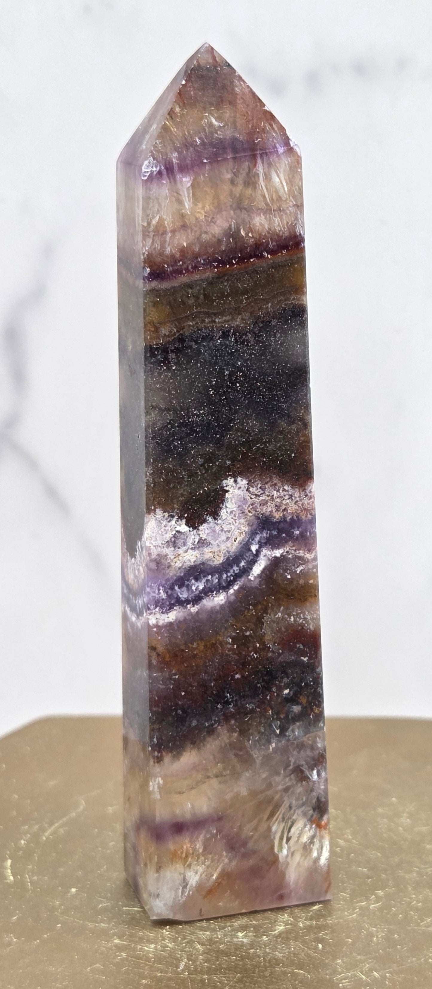 Crystal with purple and brown colors on a marble surface