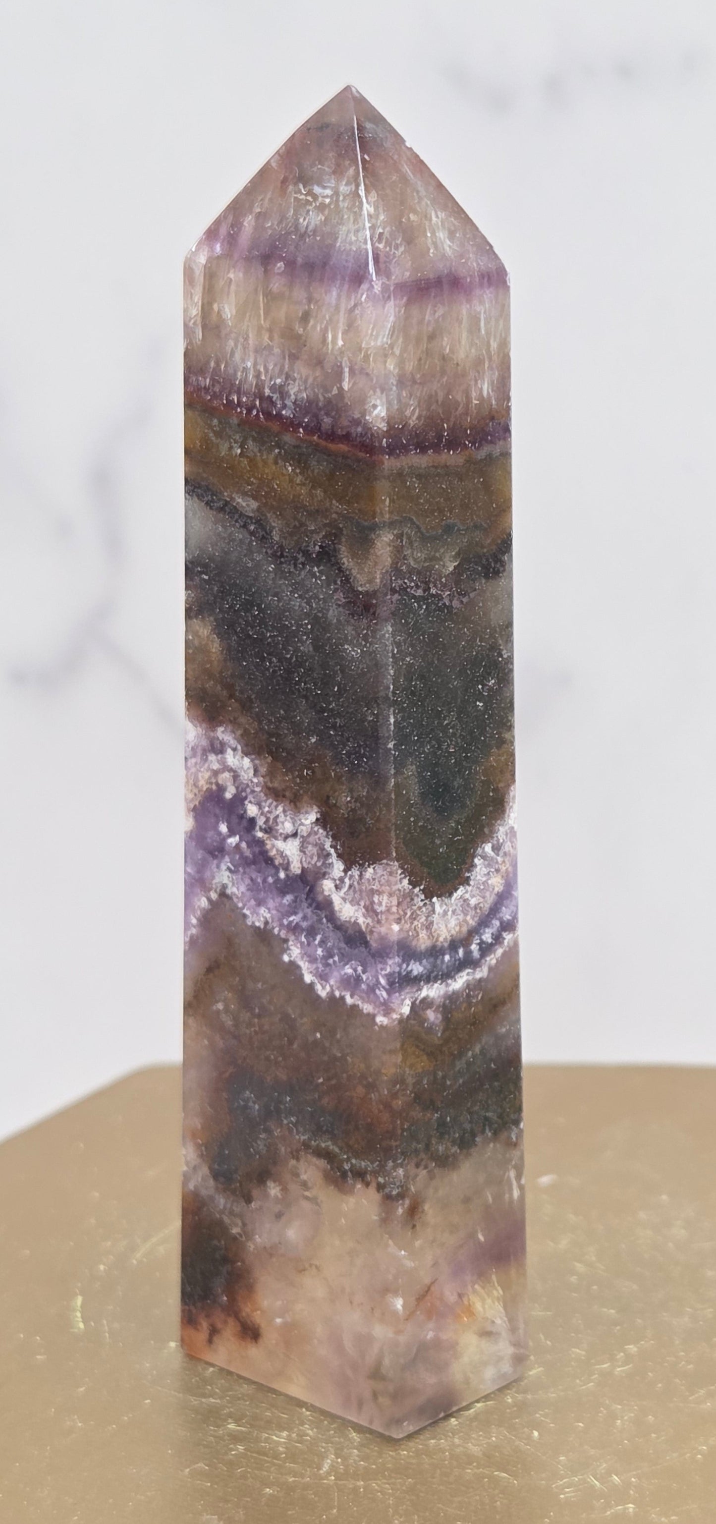 Crystal with purple and brown colors on a marble surface