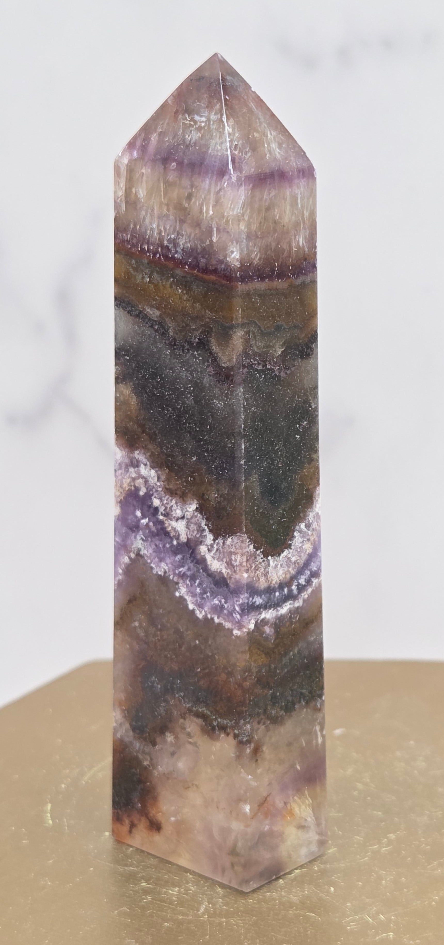Crystal with purple and brown colors on a marble surface