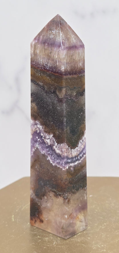 Crystal with purple and brown colors on a marble surface