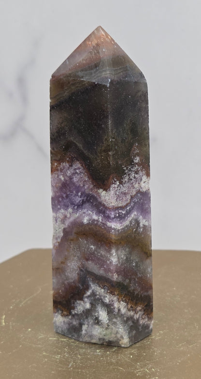 Crystal with purple and brown colors on a marble surface