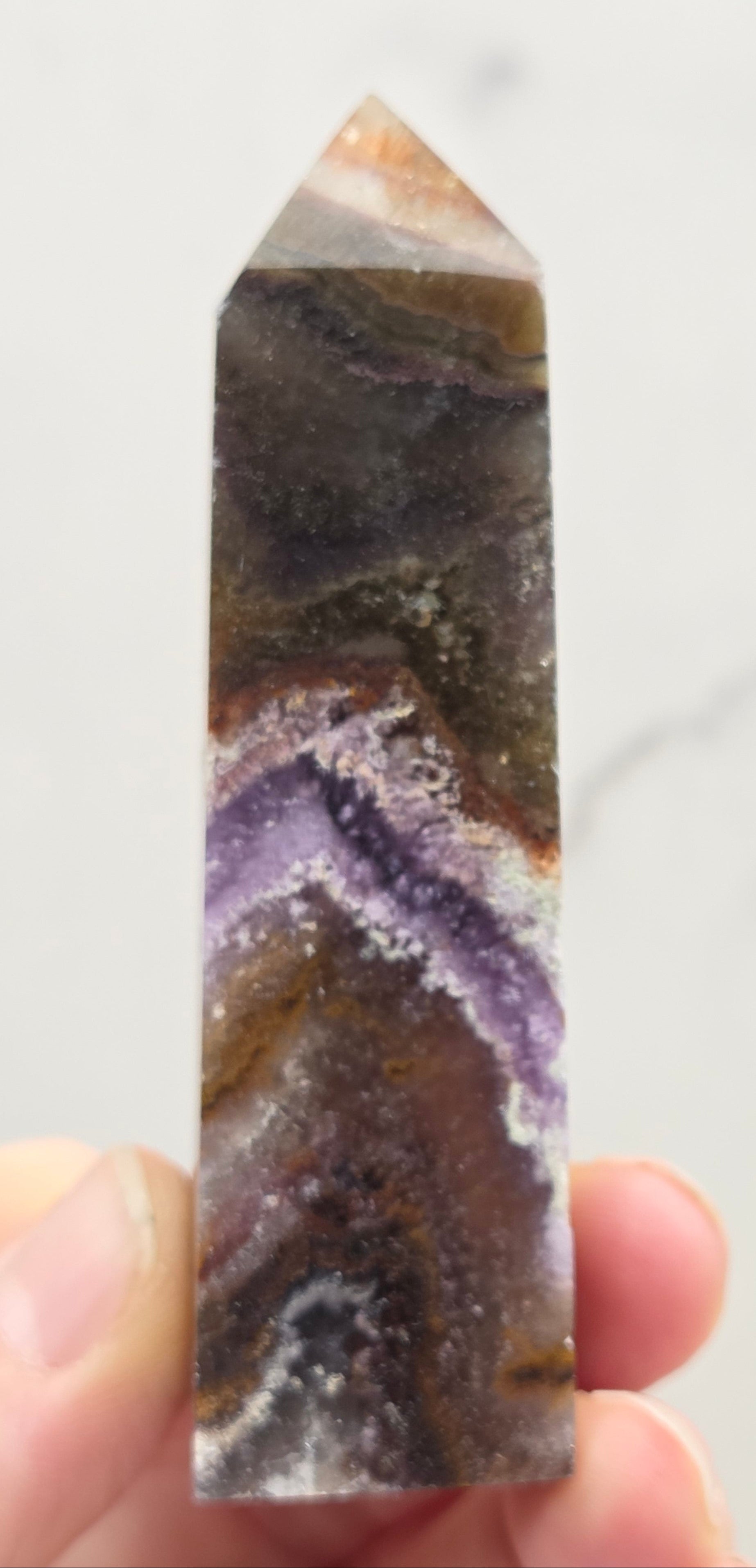 Crystal with purple and brown colors on a marble surface