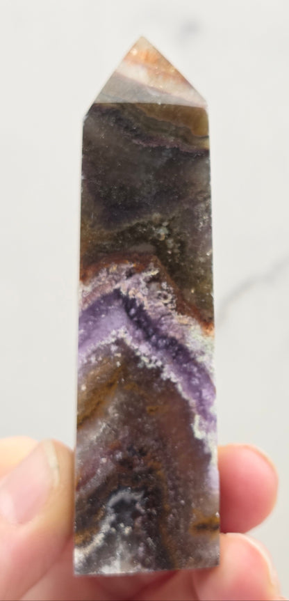 Crystal with purple and brown colors on a marble surface