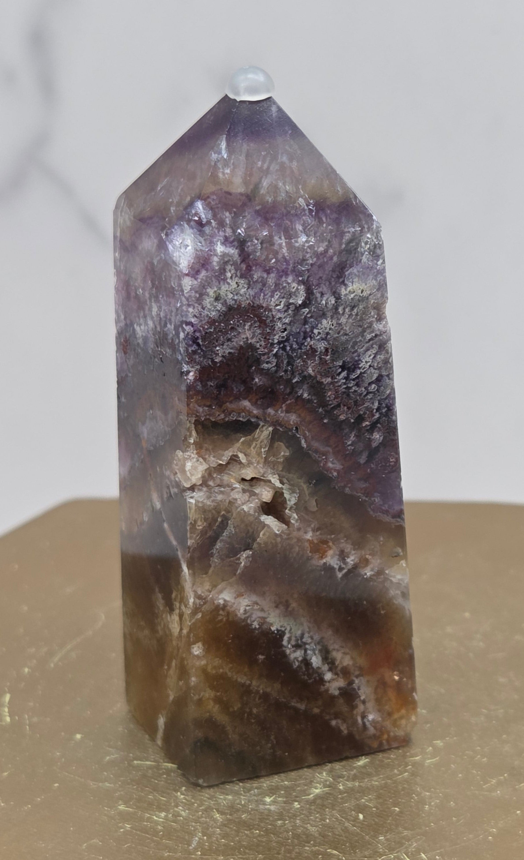 Crystal with purple and brown colors on a marble surface