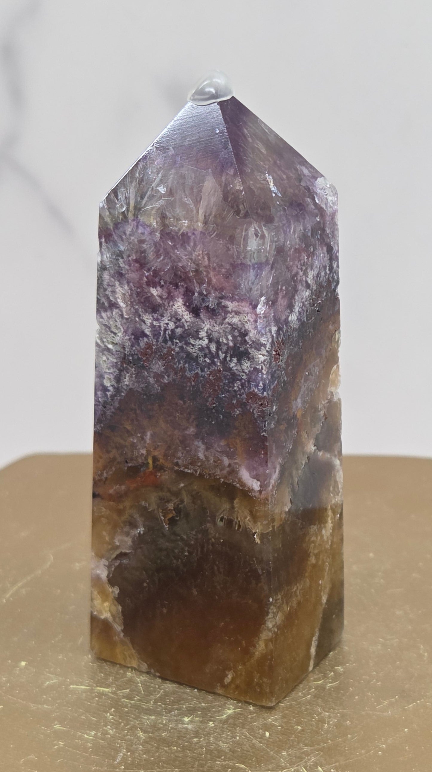 Crystal with purple and brown colors on a marble surface