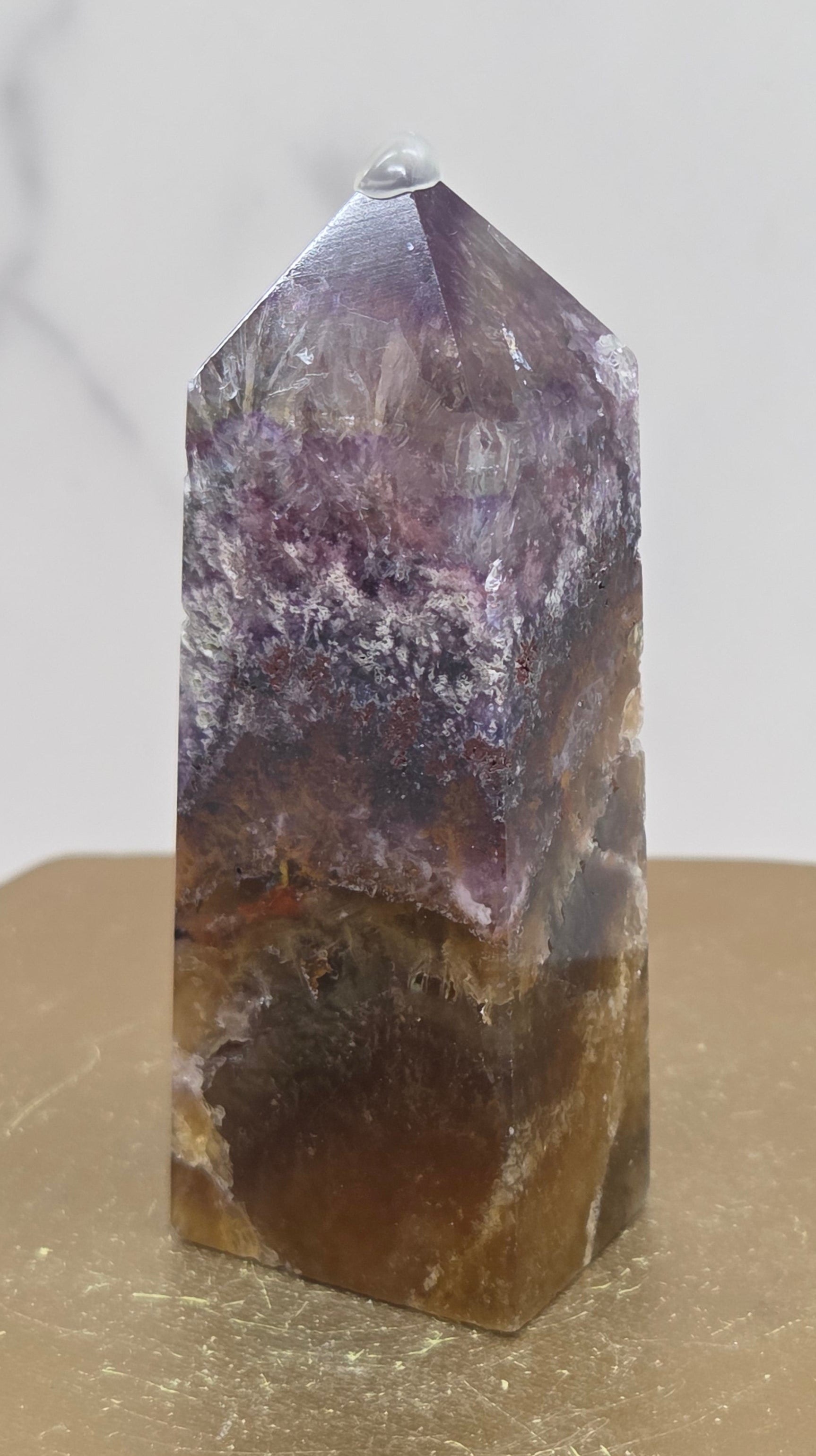Crystal with purple and brown colors on a marble surface