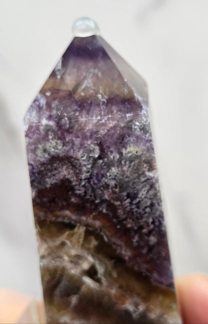 Close-up of a Crystal with purple and brown colors on a marble surface