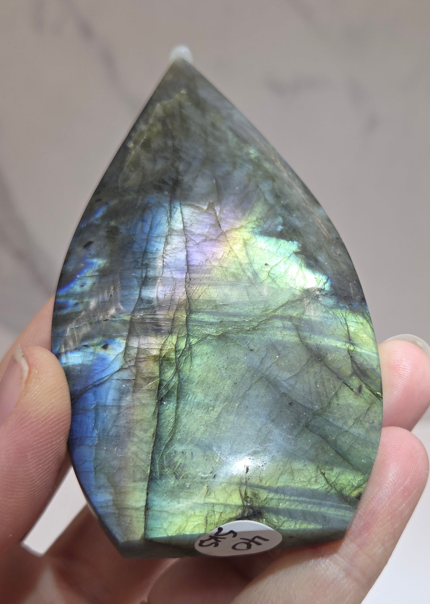 Hand holding a labradorite stone with a blurred background