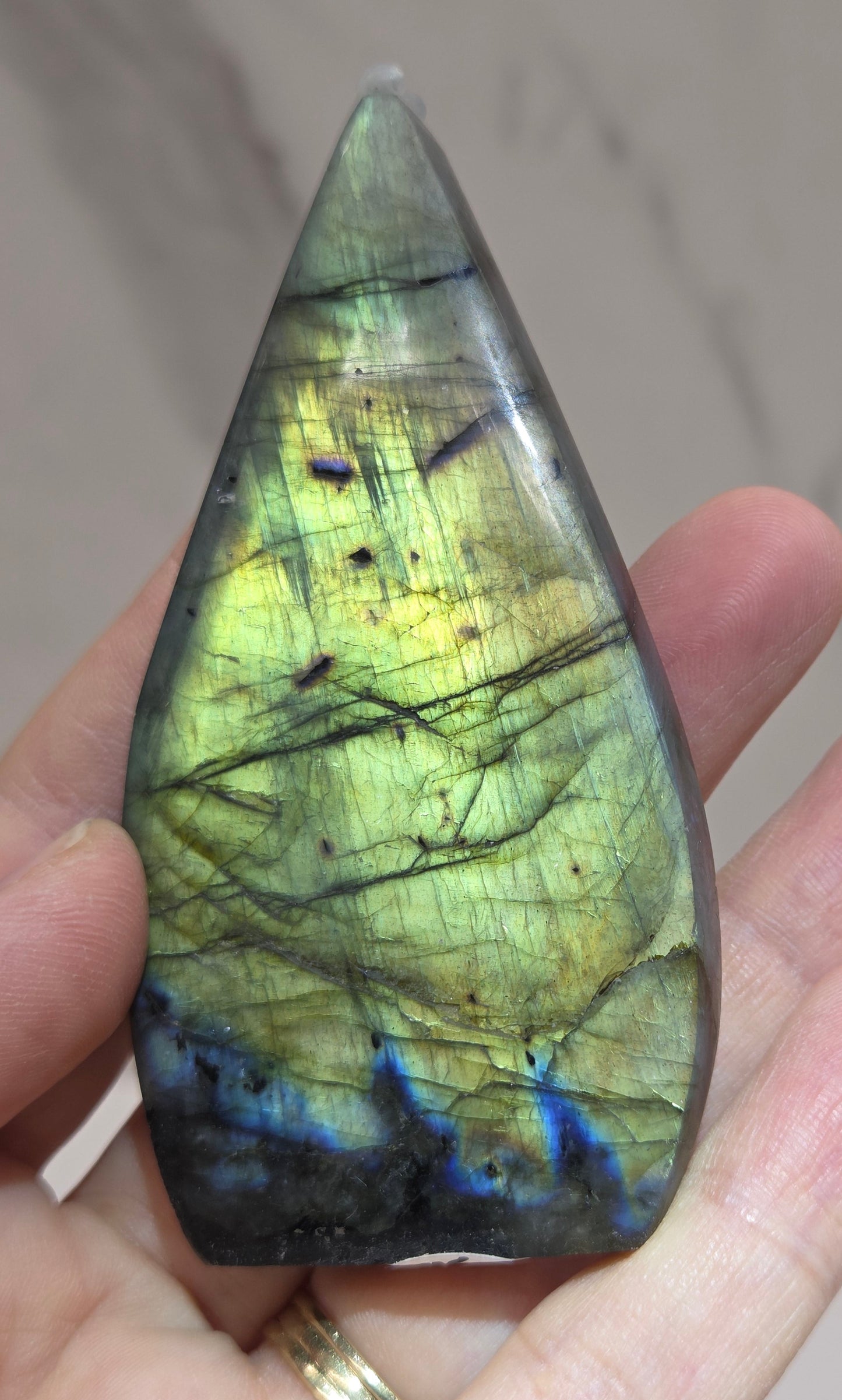 Hand holding a labradorite crystal with a marbled pattern