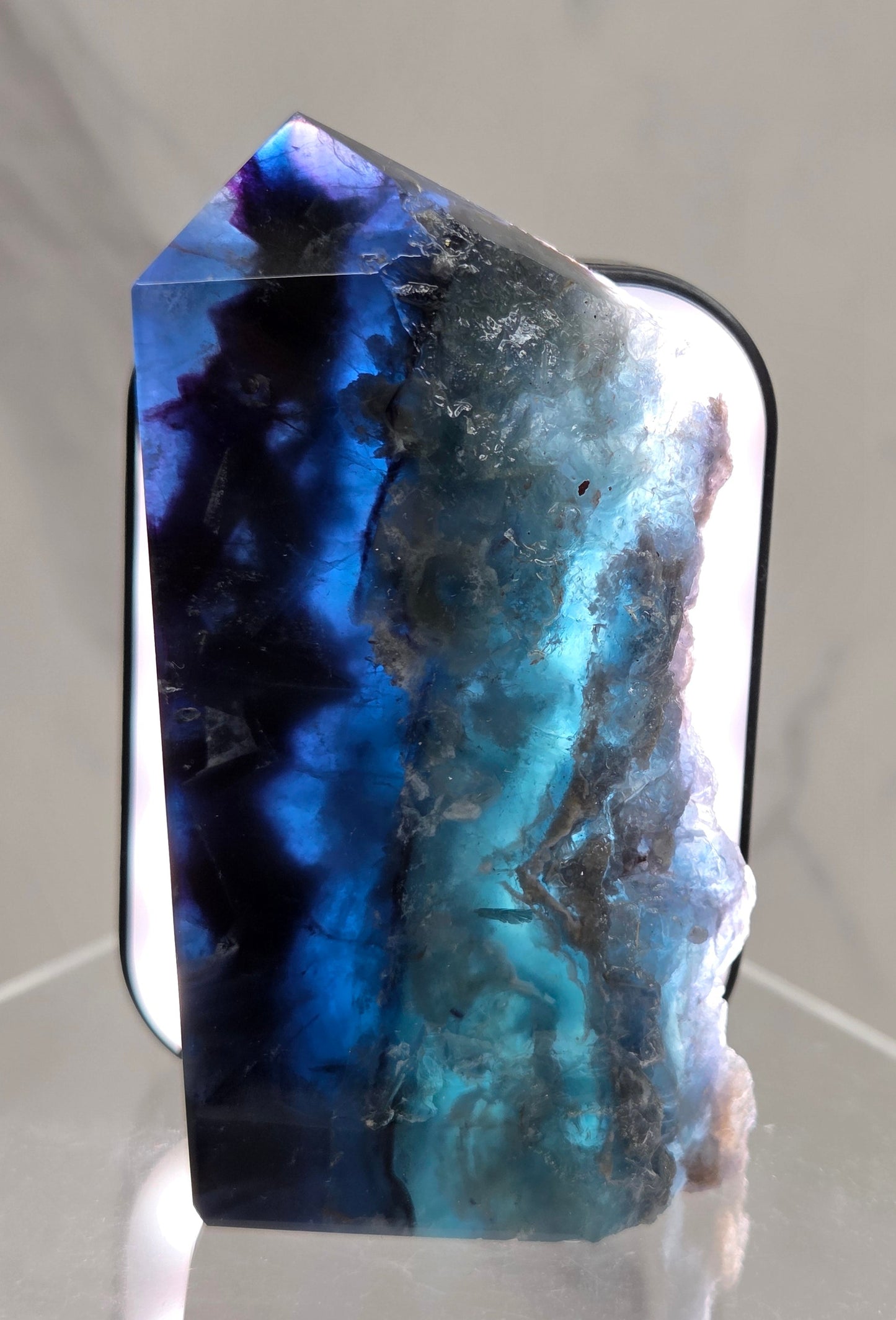 Backlit Fluorite tower with green and dark blue colors on a white surface