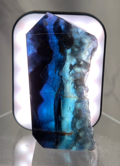 Backlit Fluorite tower with green and dark blue colors on a white surface