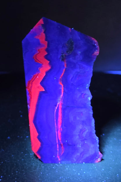 Fluorite tower under UV light on a dark surface