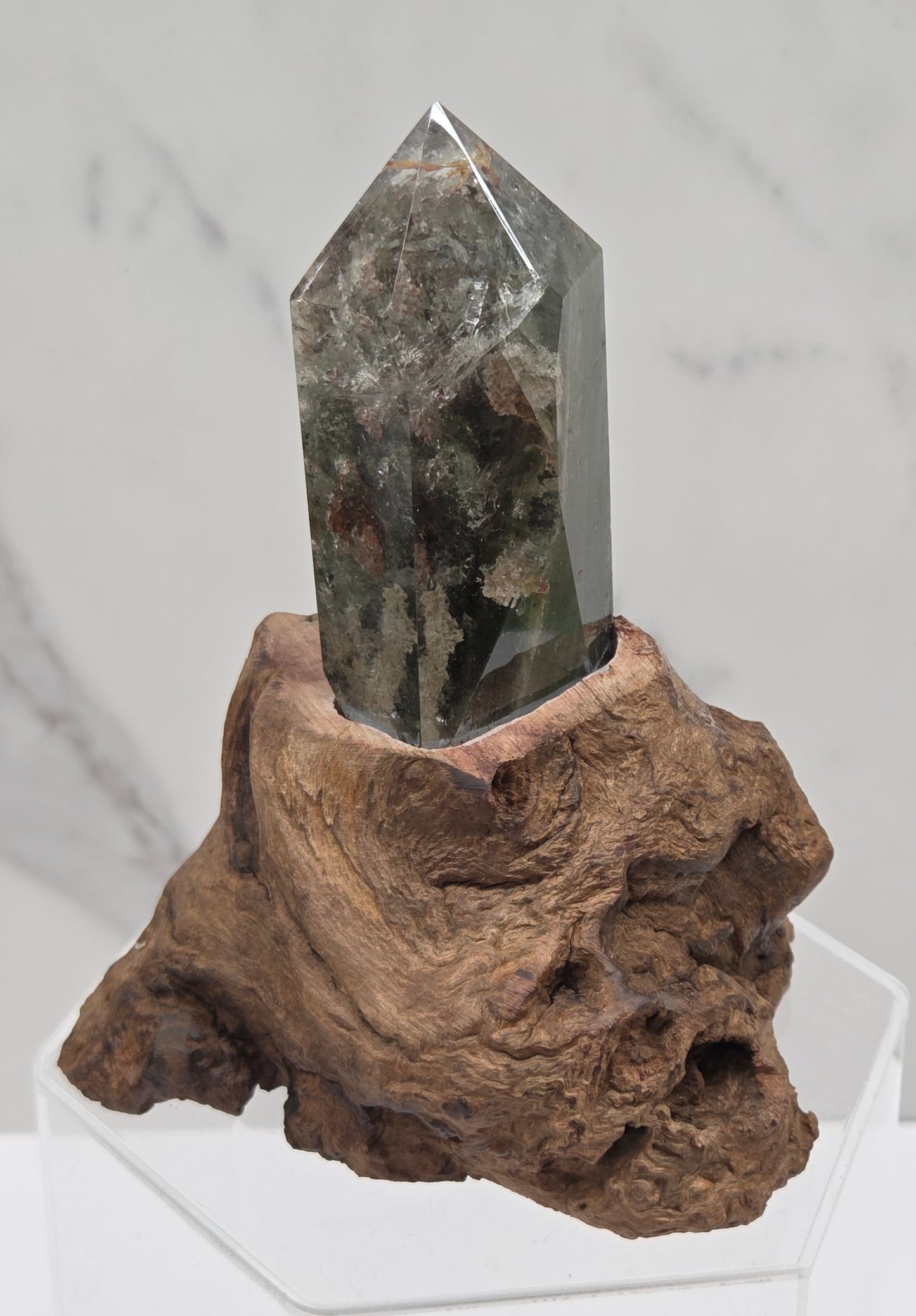 Garden Quartz crystal tower on top of  a driftwood base, set against a light background.