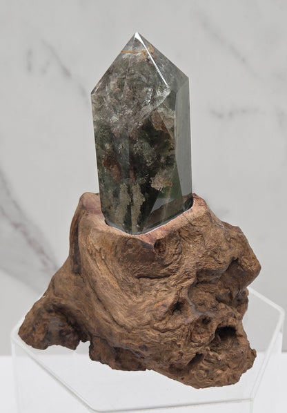 Garden Quartz crystal tower on top of  a driftwood base, set against a light background.