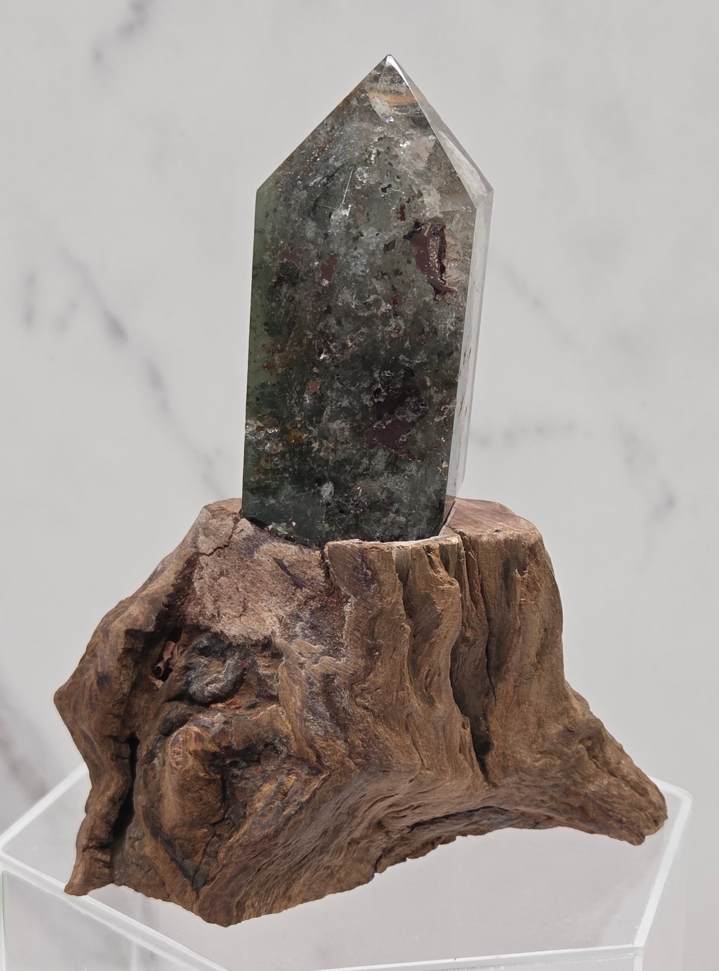 Garden Quartz crystal tower on top of  a driftwood base, set against a light background.