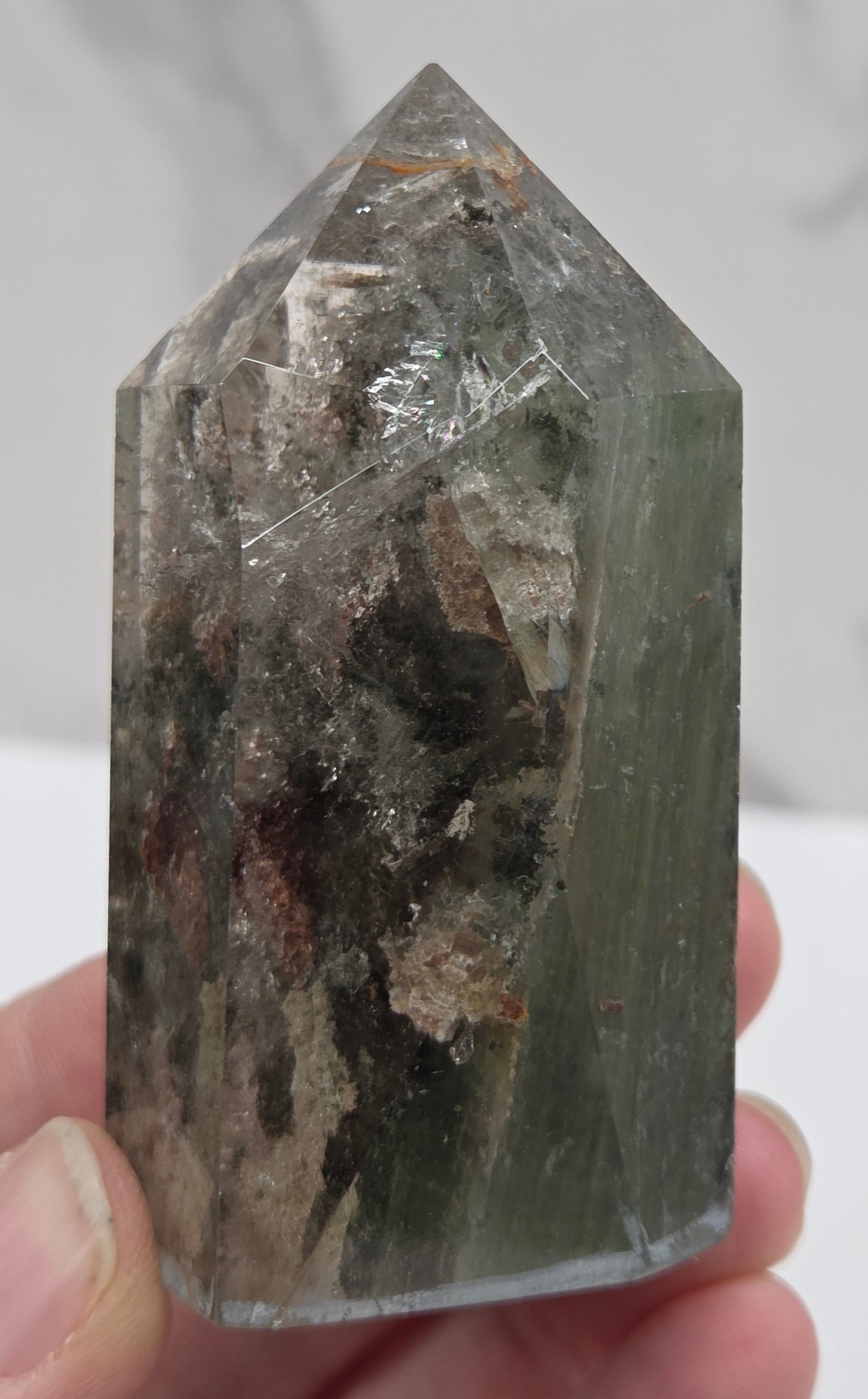 Person holding a Garden Quartz crystal with a white background