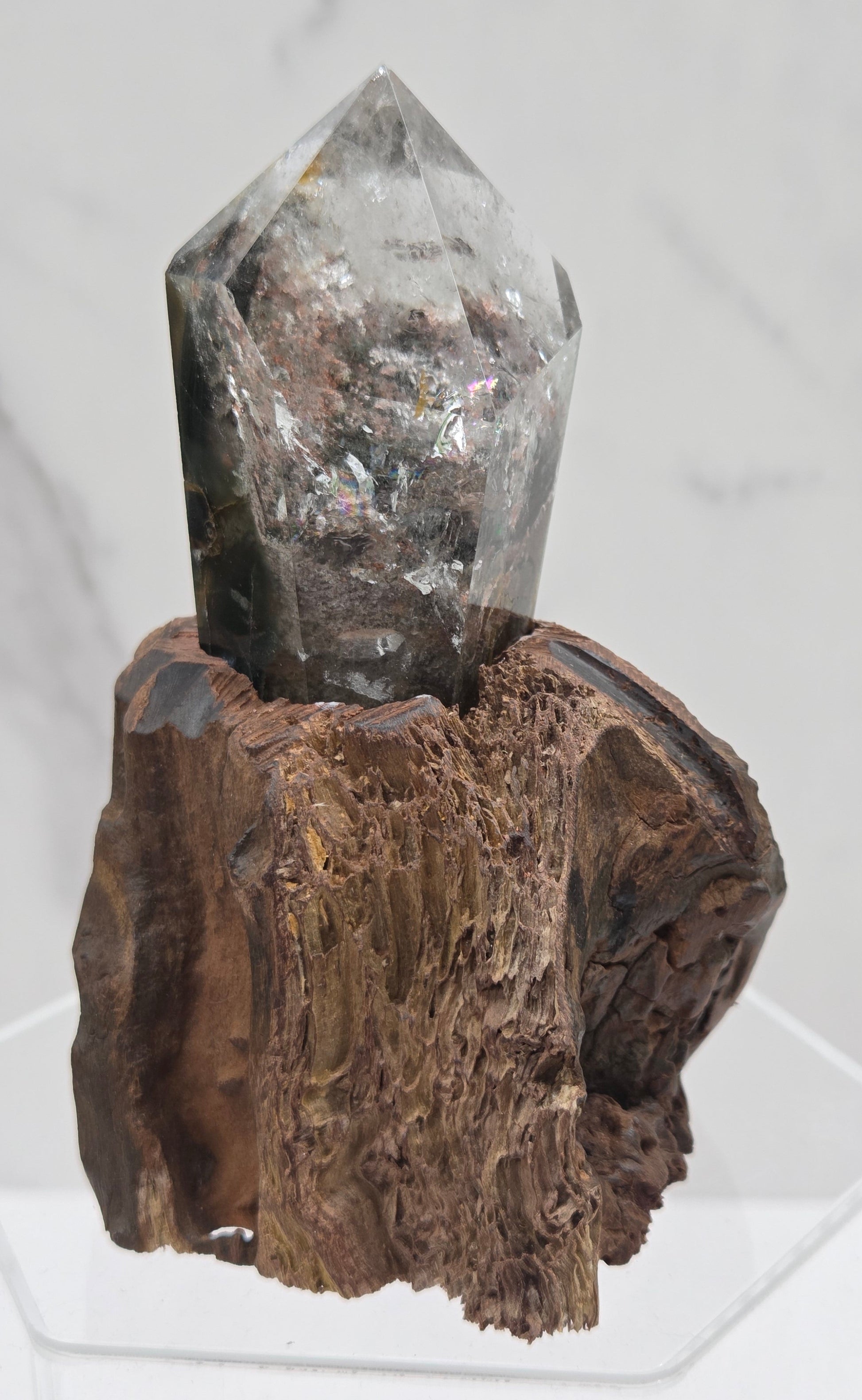 Garden Quartz crystal tower on top of  a driftwood base, set against a light background.