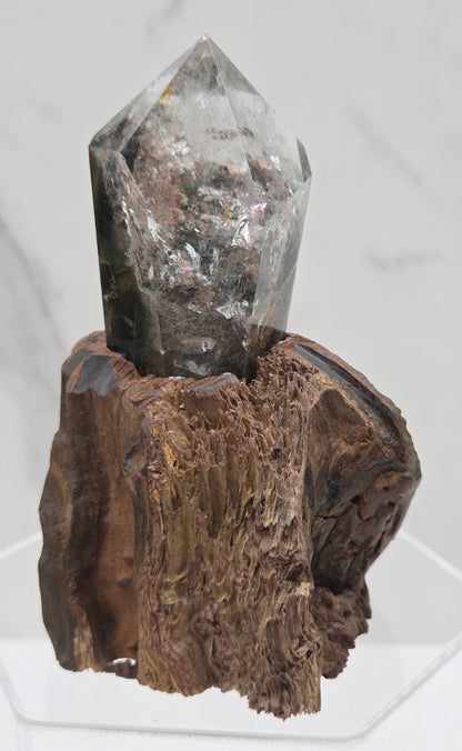 Garden Quartz crystal tower on top of  a driftwood base, set against a light background.