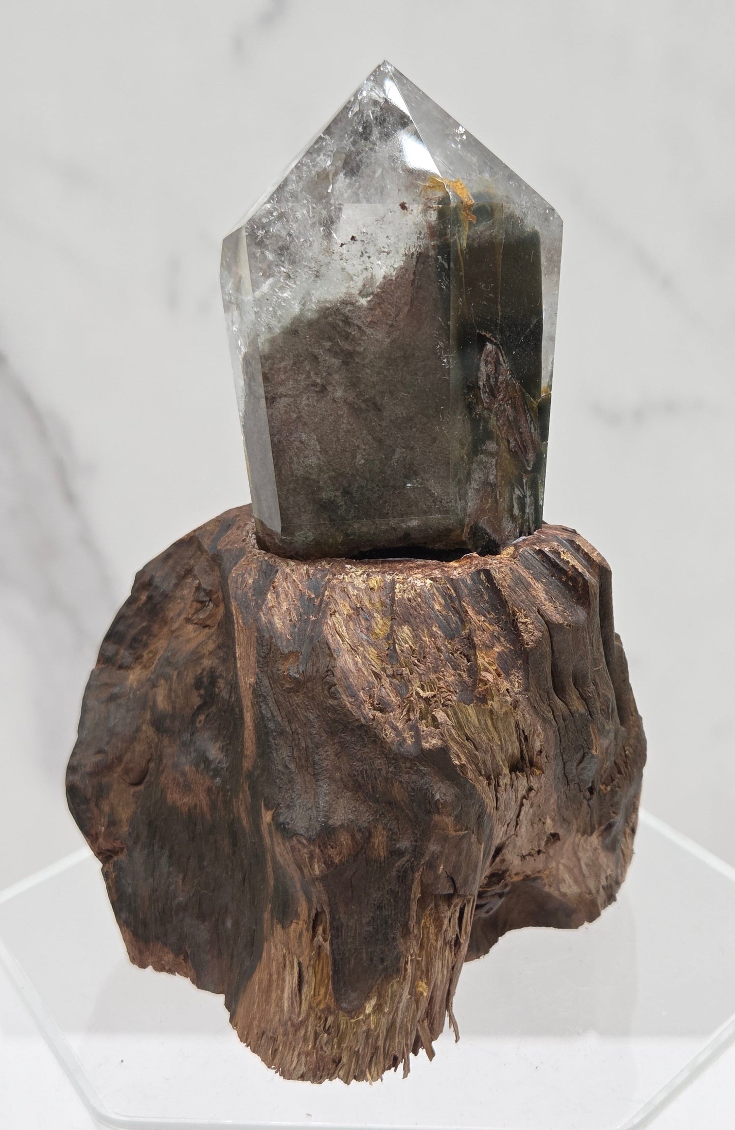 Garden Quartz crystal tower on top of  a driftwood base, set against a light background.