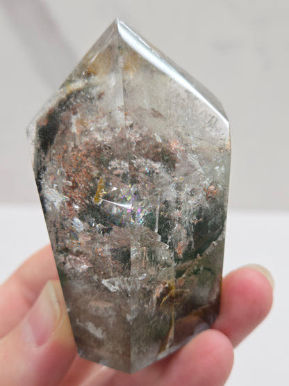 Garden Quartz Crystal held by a hand against a white background