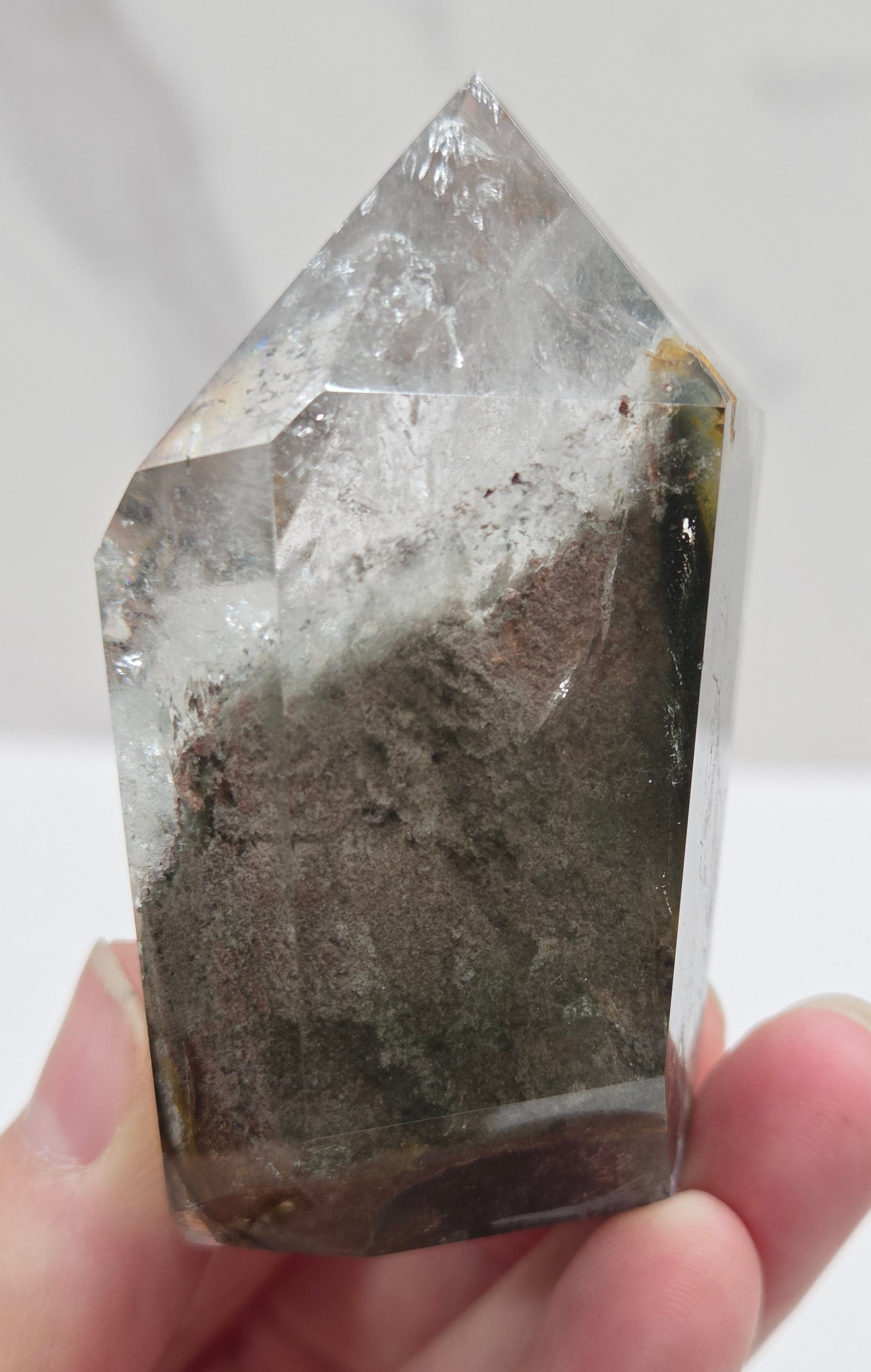 Garden Quartz Crystal held by a hand against a white background