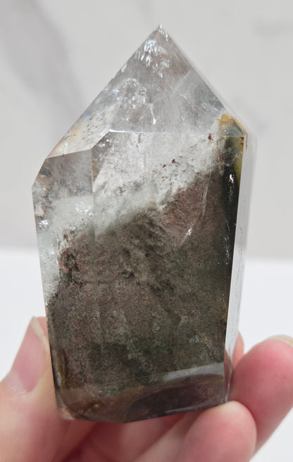 Garden Quartz Crystal held by a hand against a white background