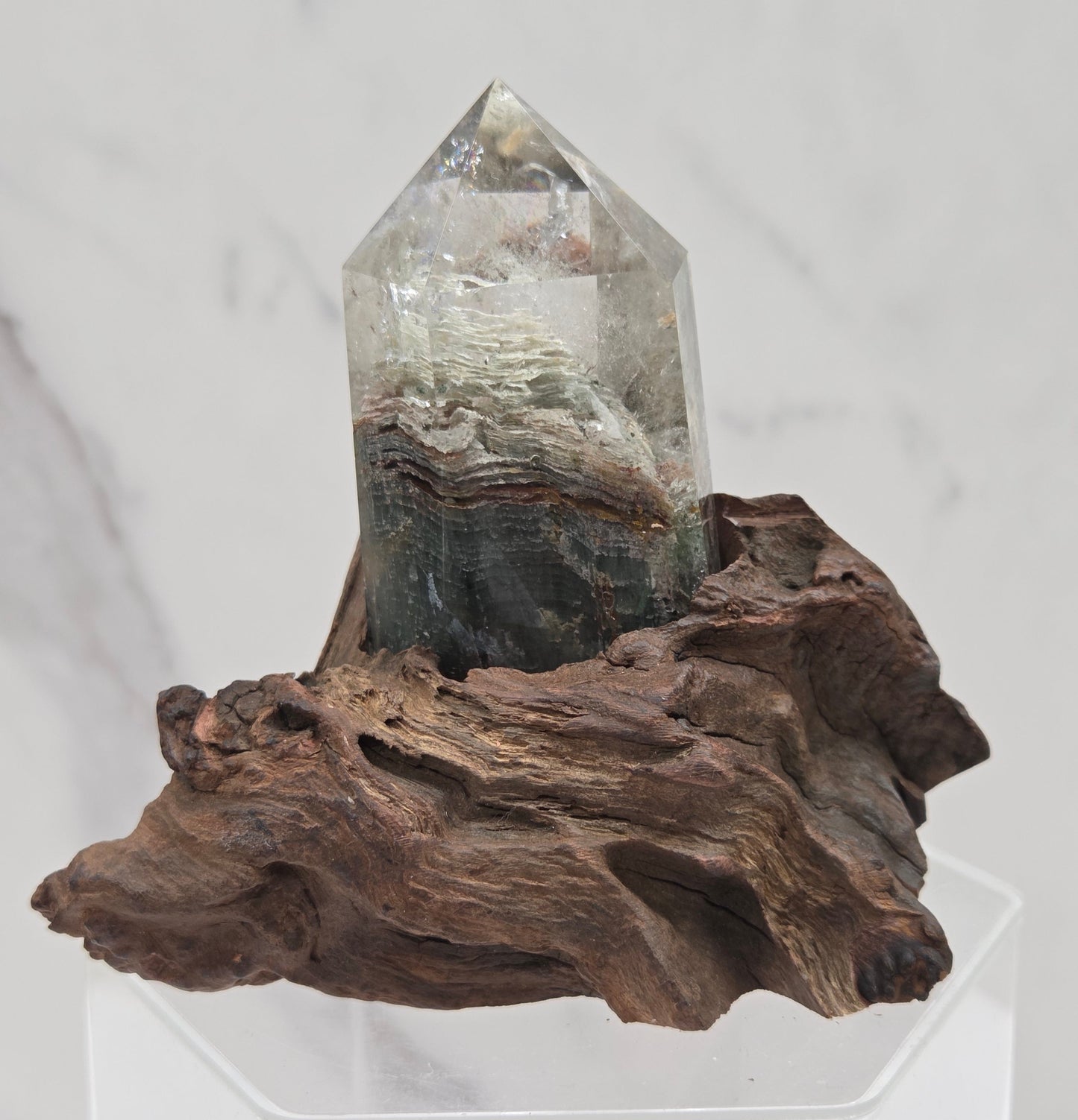 Garden Quartz crystal tower on top of  a driftwood base, set against a light background.