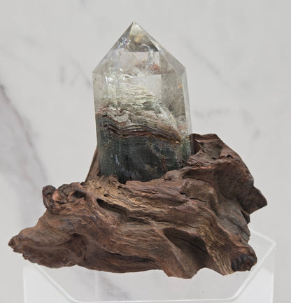 Garden Quartz crystal tower on top of  a driftwood base, set against a light background.