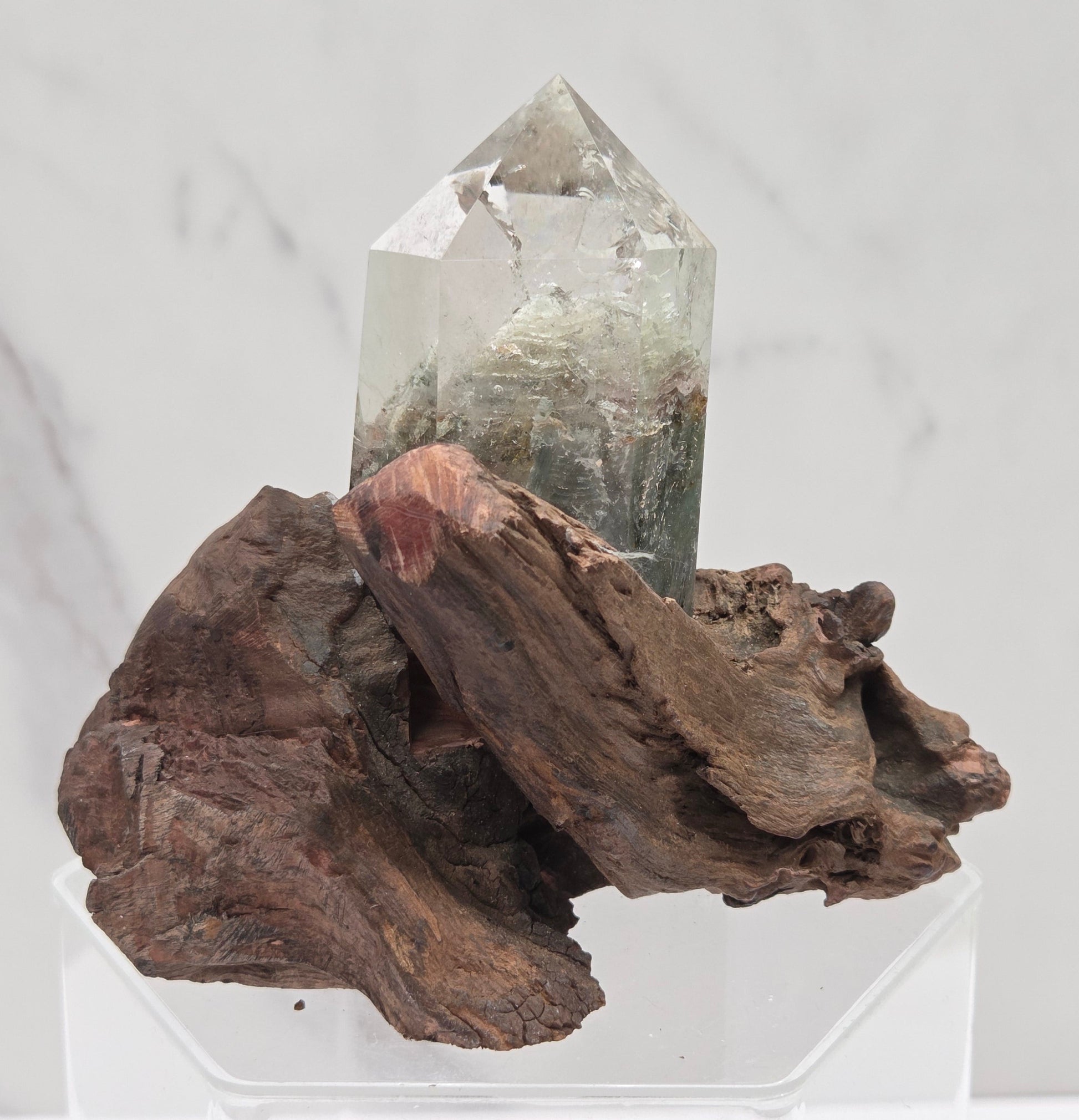 Garden Quartz crystal tower on top of  a driftwood base, set against a light background.
