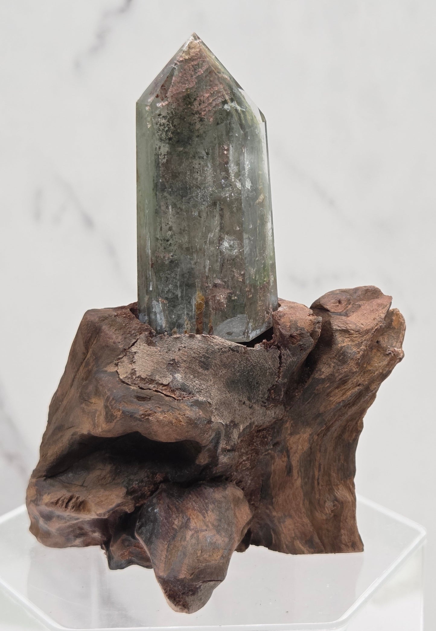 Garden Quartz crystal tower on top of  a driftwood base, set against a light background.