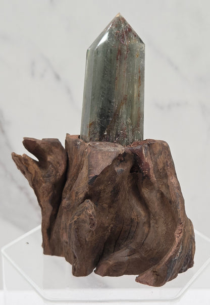 Garden Quartz crystal tower on top of  a driftwood base, set against a light background.