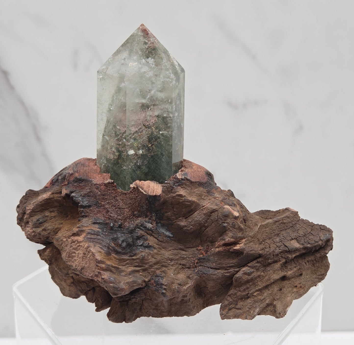 Garden Quartz crystal tower on top of  a driftwood base, set against a light background.