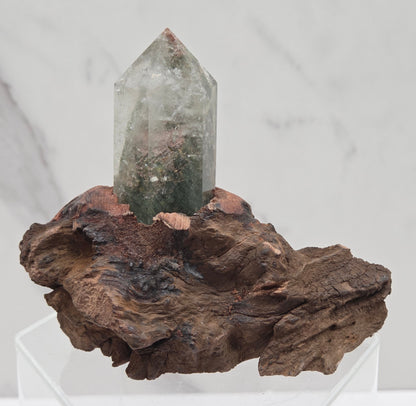 Garden Quartz crystal tower on top of  a driftwood base, set against a light background.