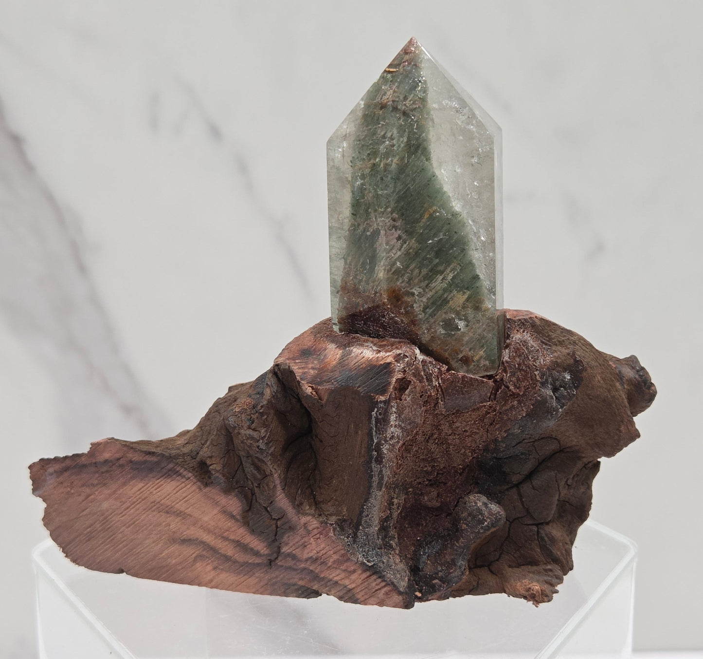 Garden Quartz crystal tower on top of  a driftwood base, set against a light background.