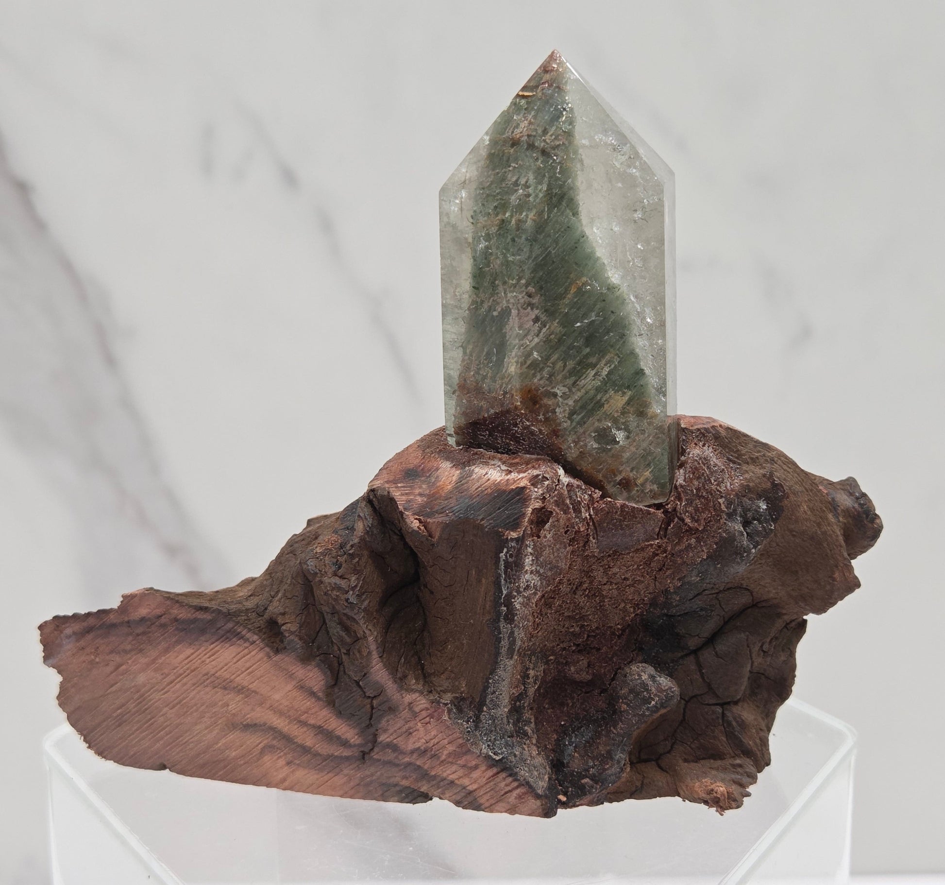 Garden Quartz crystal tower on top of  a driftwood base, set against a light background.