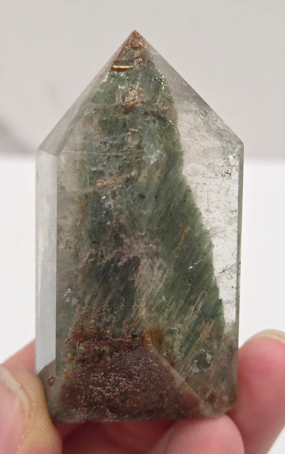 Garden Quartz Crystal held by a hand against a white background