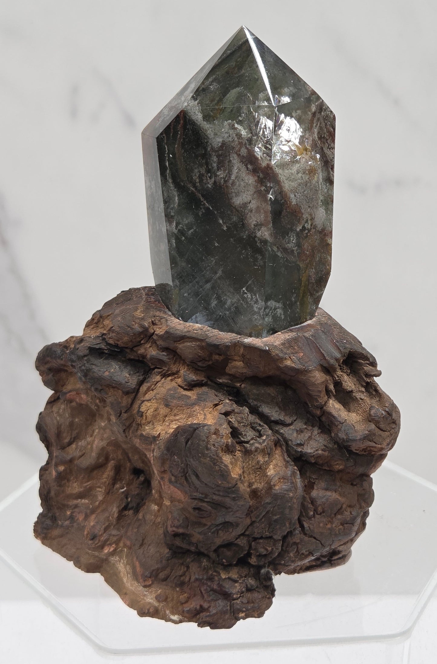 Garden Quartz crystal tower on top of  a driftwood base, set against a light background.