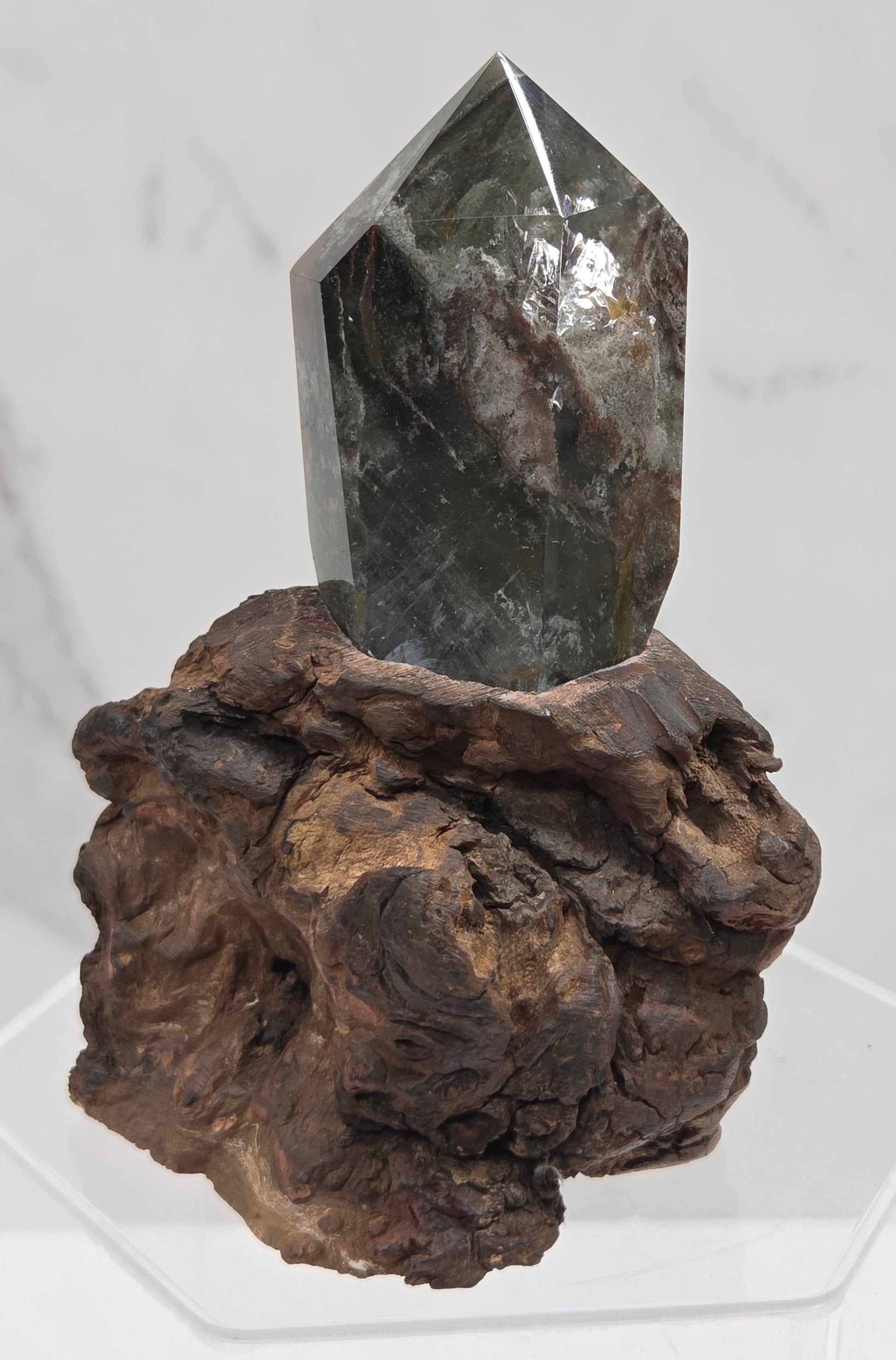 Garden Quartz crystal tower on top of  a driftwood base, set against a light background.