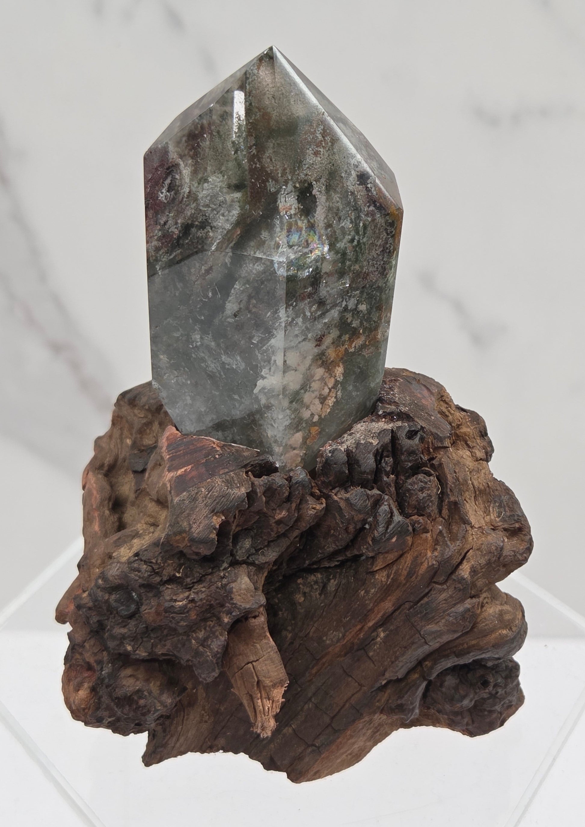 Garden Quartz crystal tower on top of  a driftwood base, set against a light background.