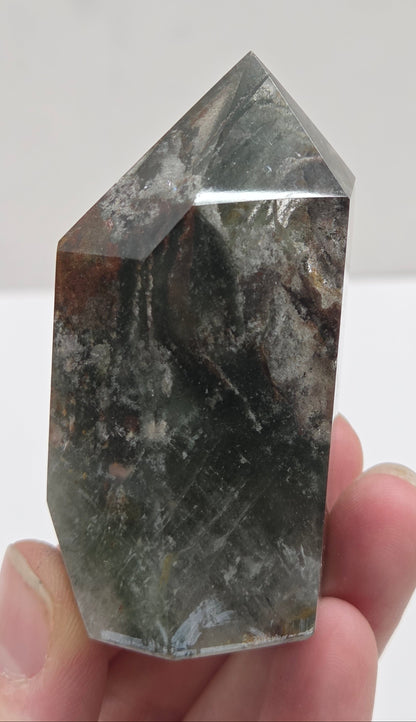 Person holding a garden Quartz crystal against a white background