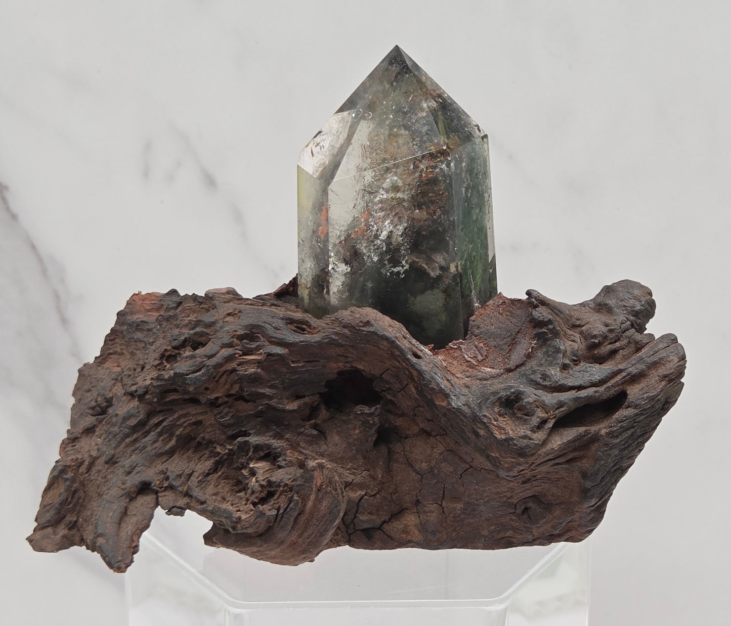Garden Quartz crystal tower on top of  a driftwood base, set against a light background.