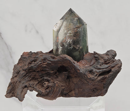 Garden Quartz crystal tower on top of  a driftwood base, set against a light background.